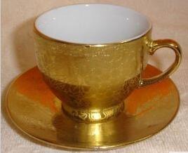 Golden ceramic coffee cup and saucer